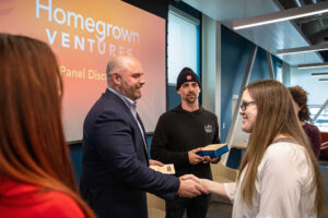 Homegrown Ventures conference with speaker Gus Minor shaking hands with event host Heather Dufour