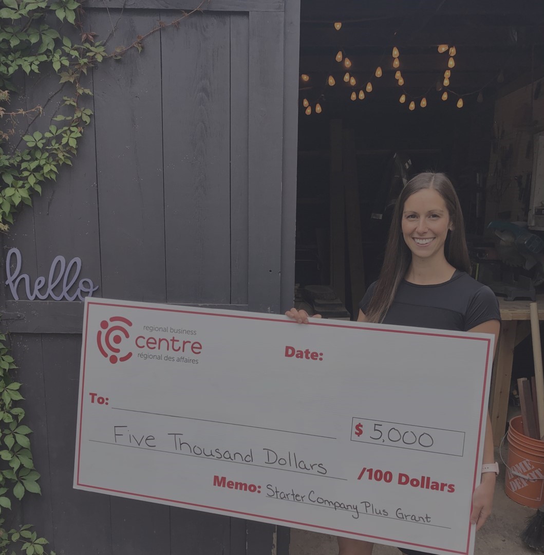 woman holding a cheque for $5,000 with the starter company plus program